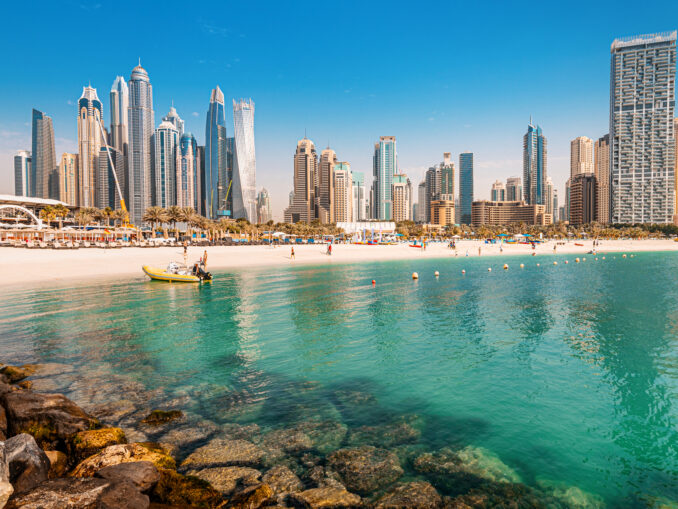 Sandstrand mit Urlaubern in Dubai